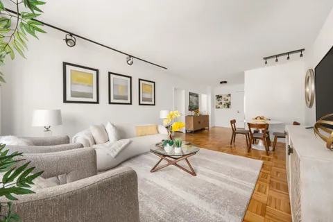 a living room with furniture a flat screen tv and a table