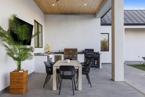 a dining room with furniture and potted plants