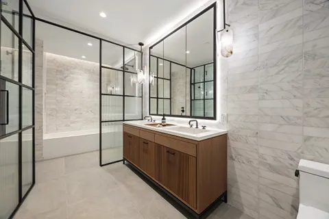 a bathroom with a sink and mirror with bathtub