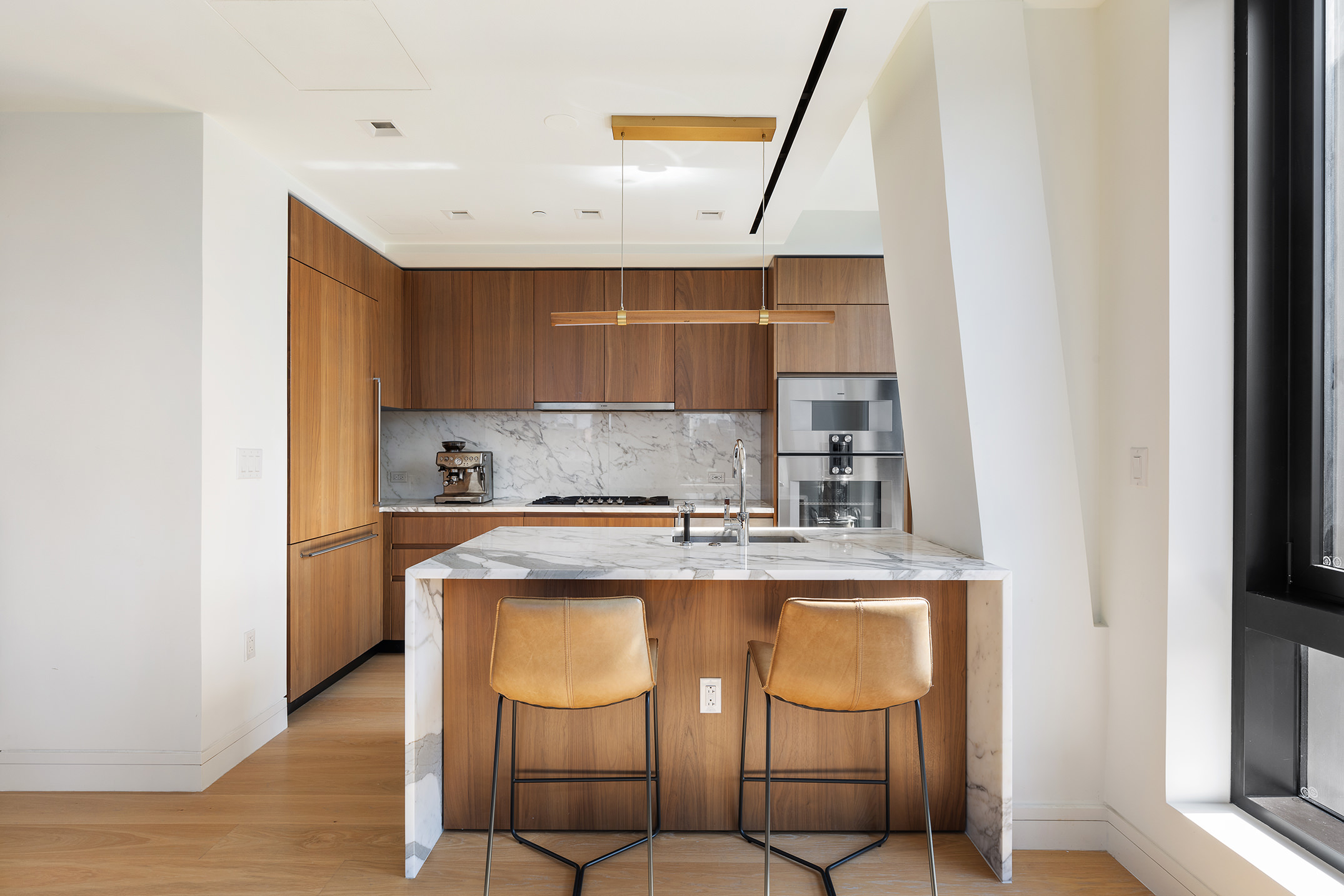 242 Broome Street, Unit 7C Manhattan, NY 10002 - Photo 2 of 7 a kitchen with stainless steel appliances granite countertop a sink and cabinets