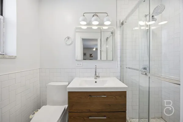 a bathroom with a sink a toilet and mirror