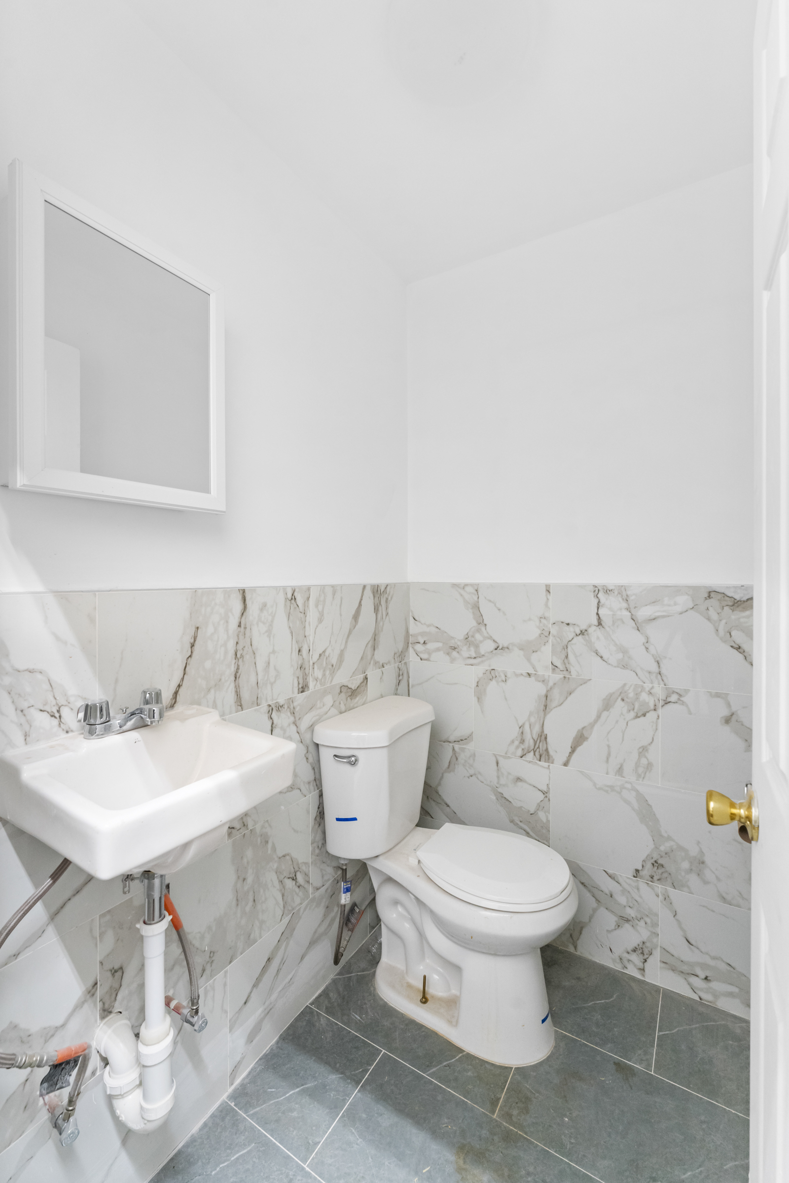 187 Maujer Street Brooklyn, NY 11206 - Photo 11 of 12 a white toilet sitting next to a bathroom sink