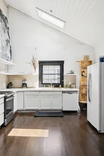 a large white kitchen with a stove a sink dishwasher and a refrigerator