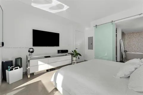 a bedroom with a bed and a flat screen tv