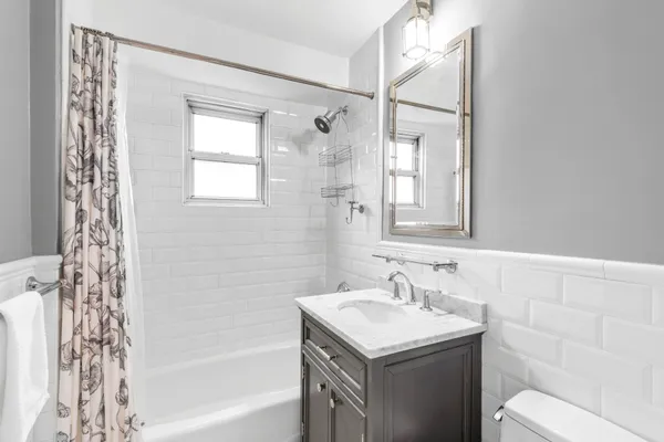 a bathroom with a granite countertop sink a toilet and shower