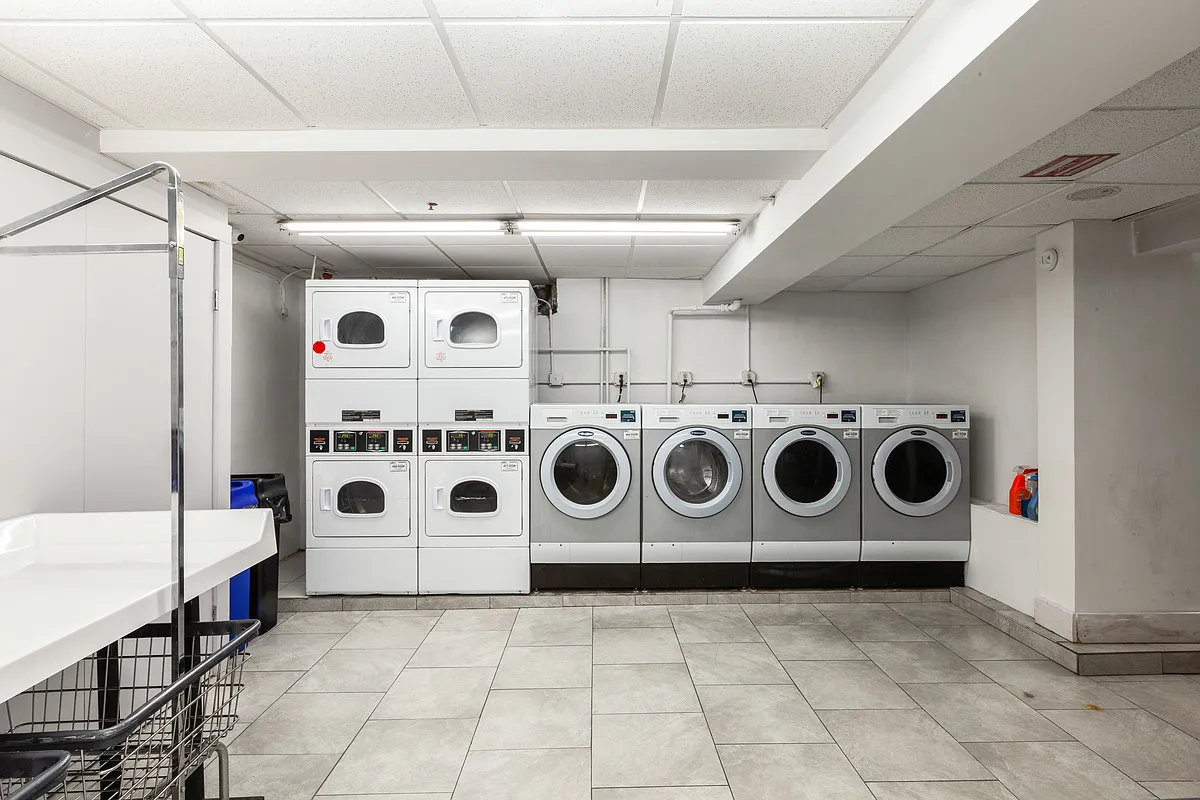 48 West 138th Street, Unit 5J Manhattan, NY 10037 - Photo 10 of 13 a utility room with stainless steel appliances a stove a washer and dryer