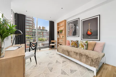 a living room with furniture and a large window with potted plants