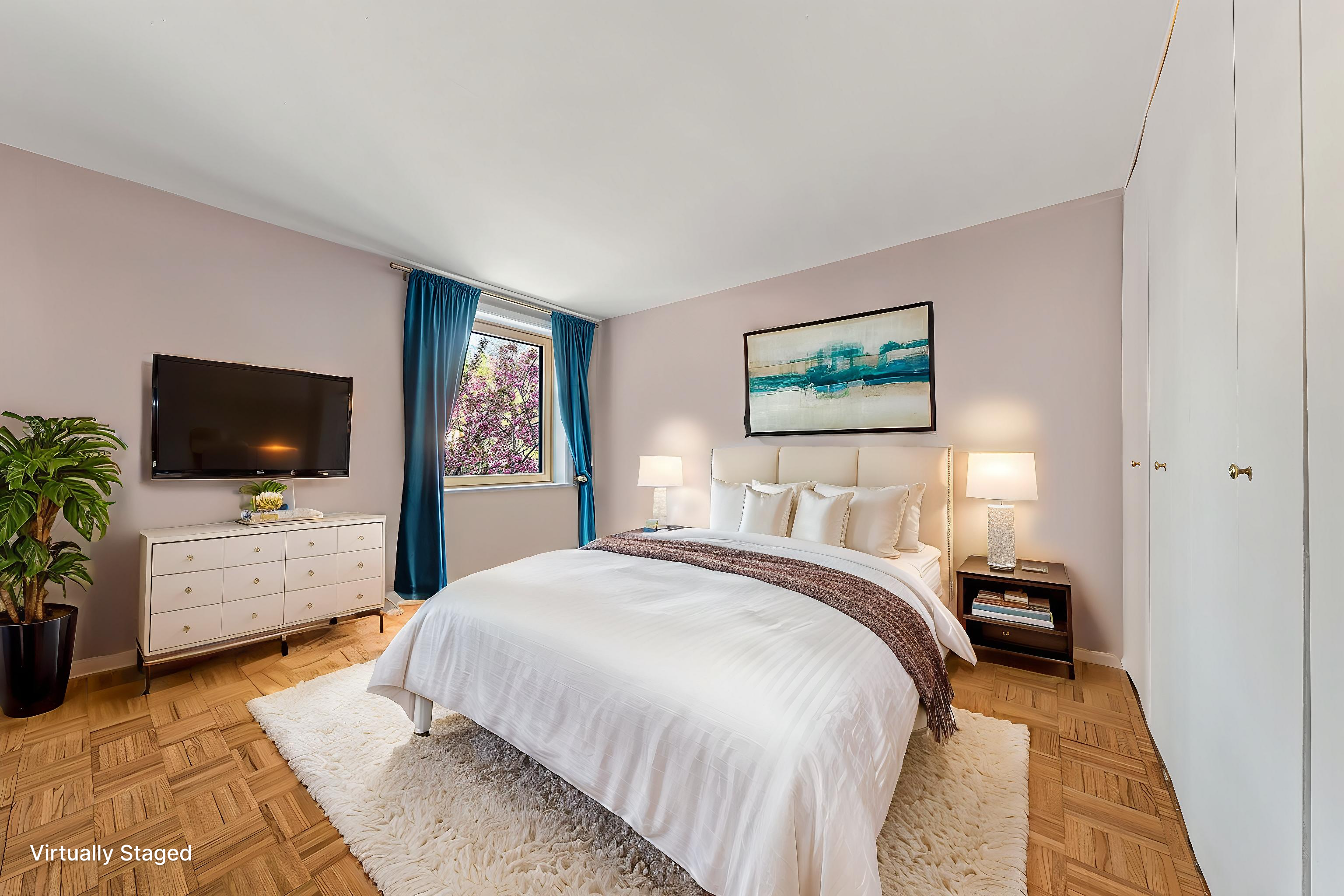 680 Washington Street, Unit 1B Manhattan, NY 10014 - Photo 6 of 13 a bedroom with a bed and a flat screen tv