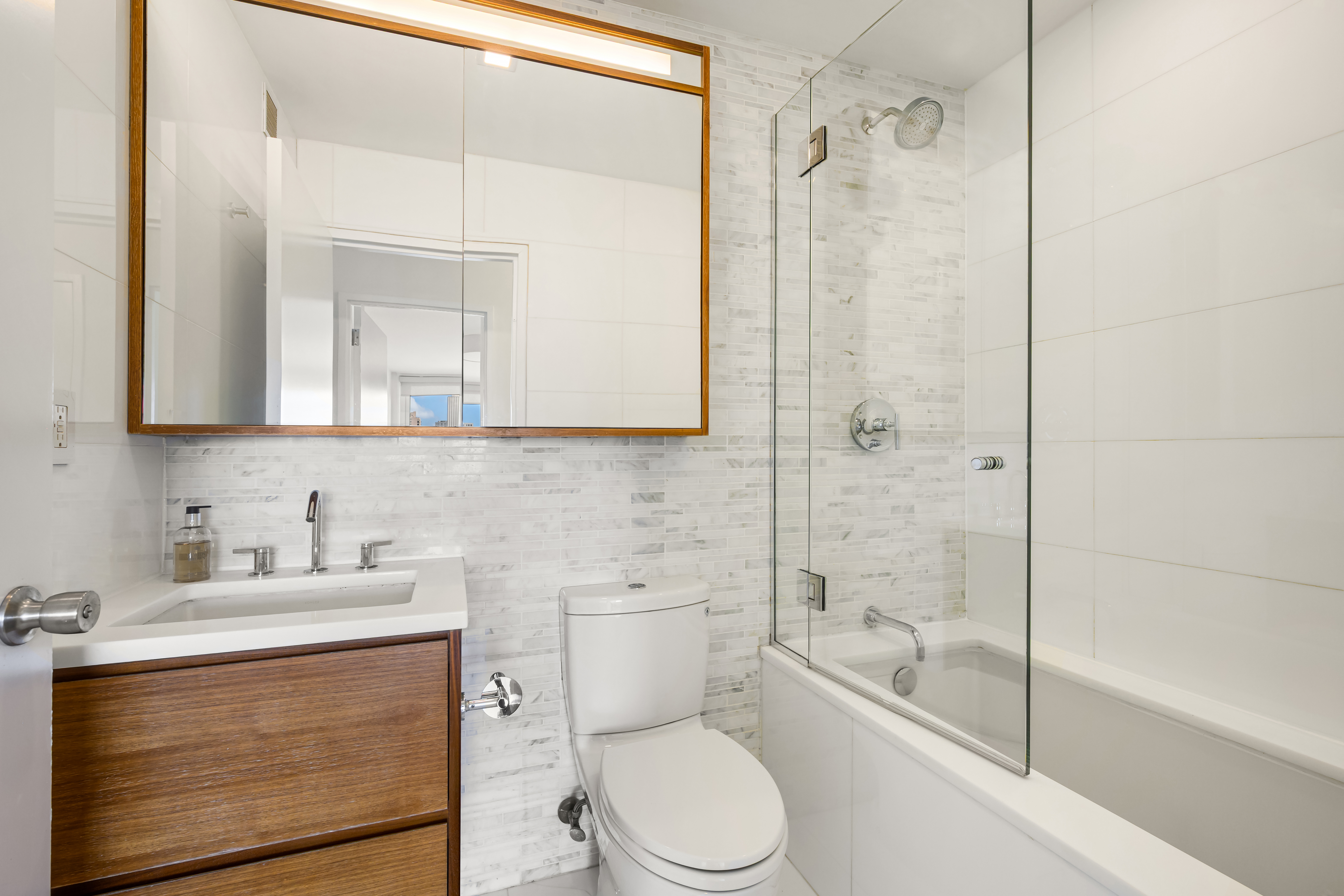 301 West 53rd Street, Unit 13C Manhattan, NY 10019 - Photo 6 of 13 a bathroom with a sink a toilet and shower