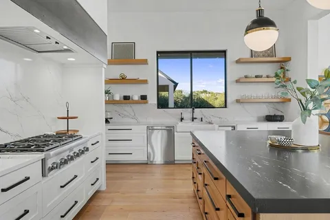 a kitchen with stainless steel appliances a sink stove and cabinets