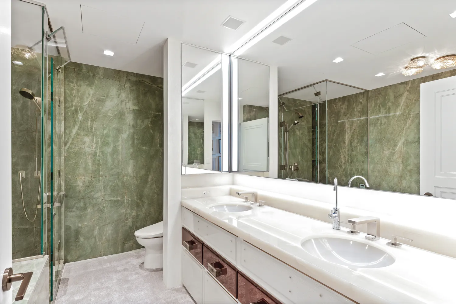 a bathroom with a shower sink vanity and toilet