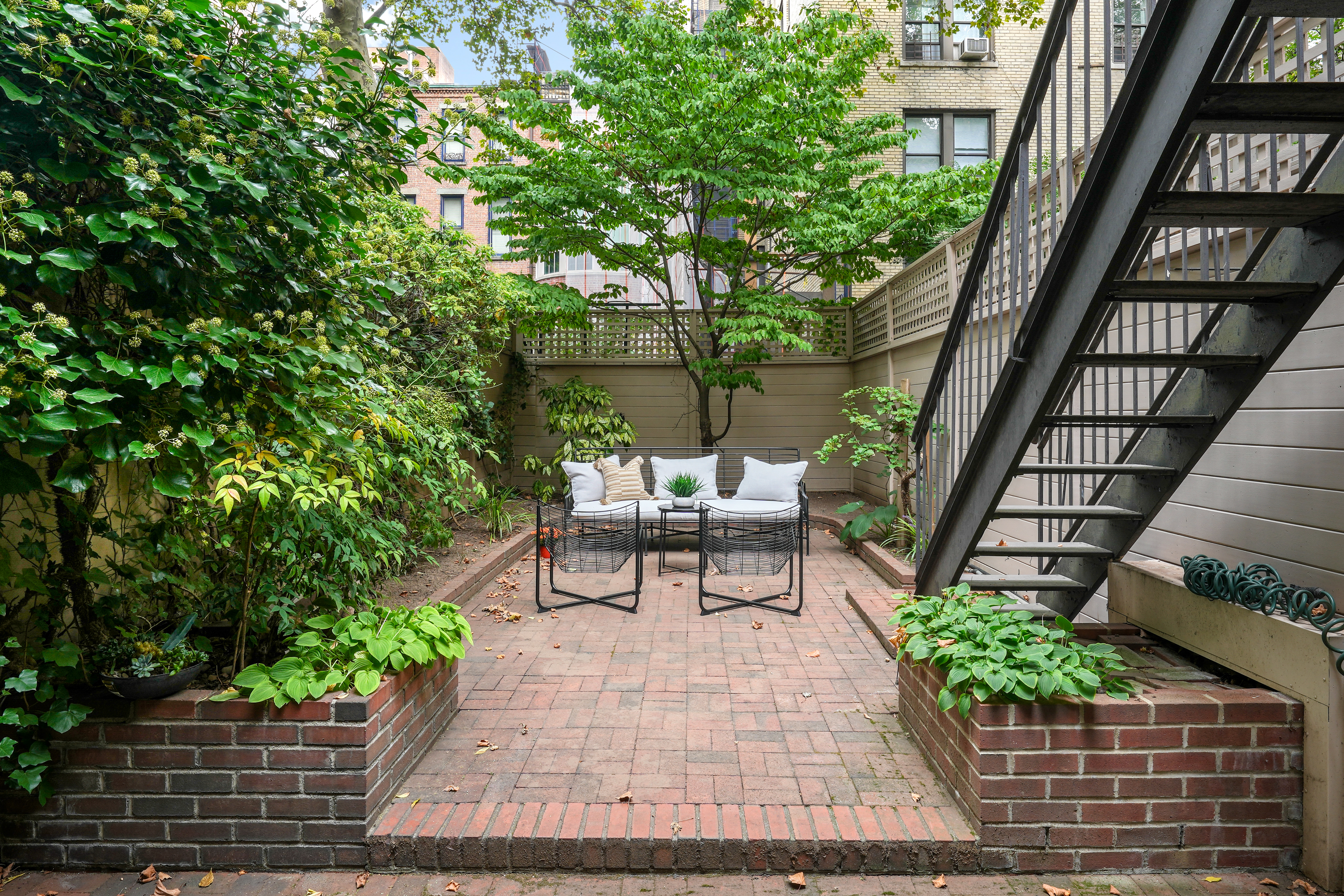247 East 71st Street Manhattan, NY 10021 - Photo 8 of 31 a bench sitting in backside of a house with potted plants and wooden walls