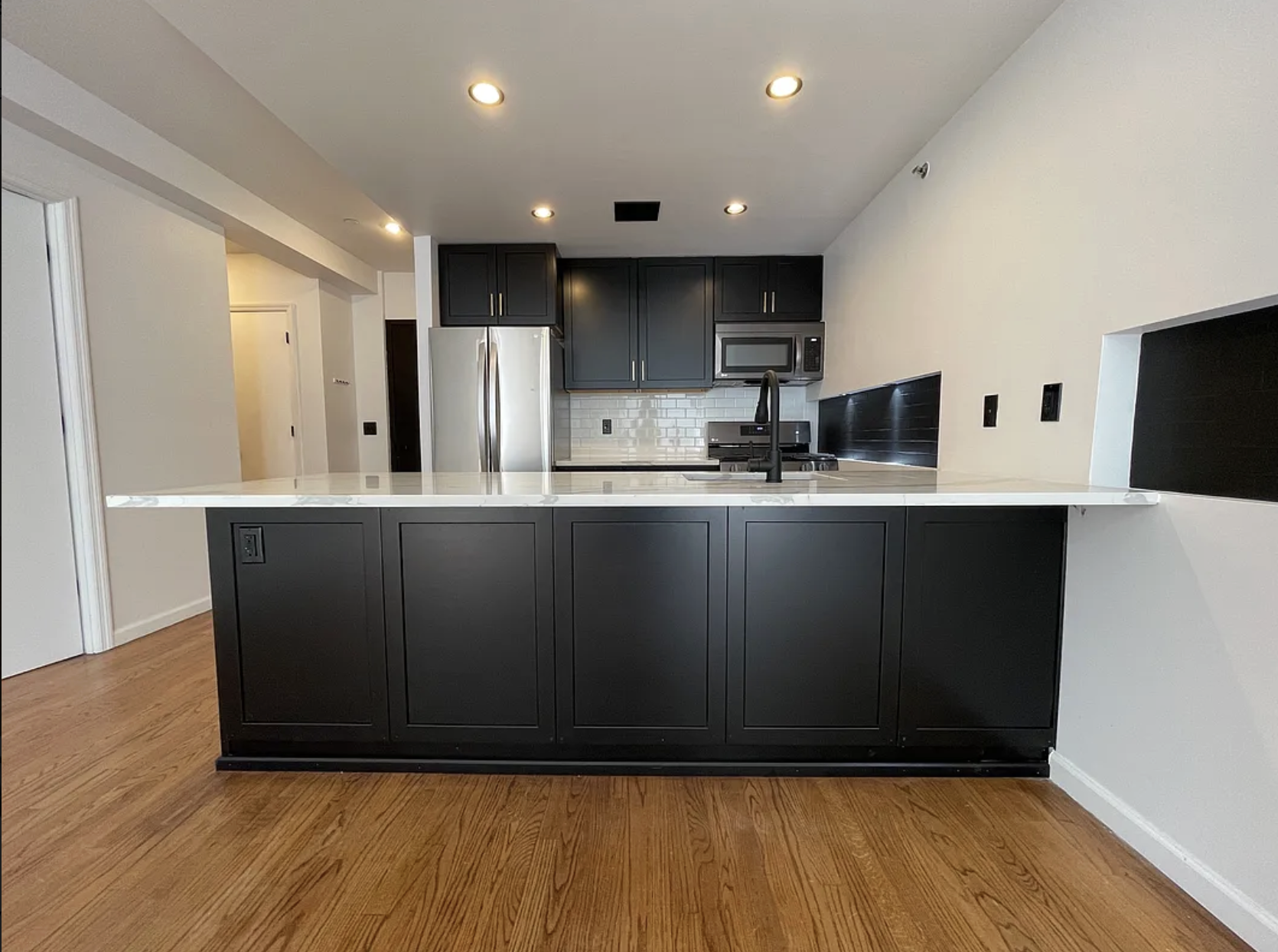 34 Crooke Avenue, Unit 4B Brooklyn, NY 11226 - Photo 1 of 12 a kitchen with stainless steel appliances granite countertop a sink a stove a refrigerator a microwave and island with wooden floor