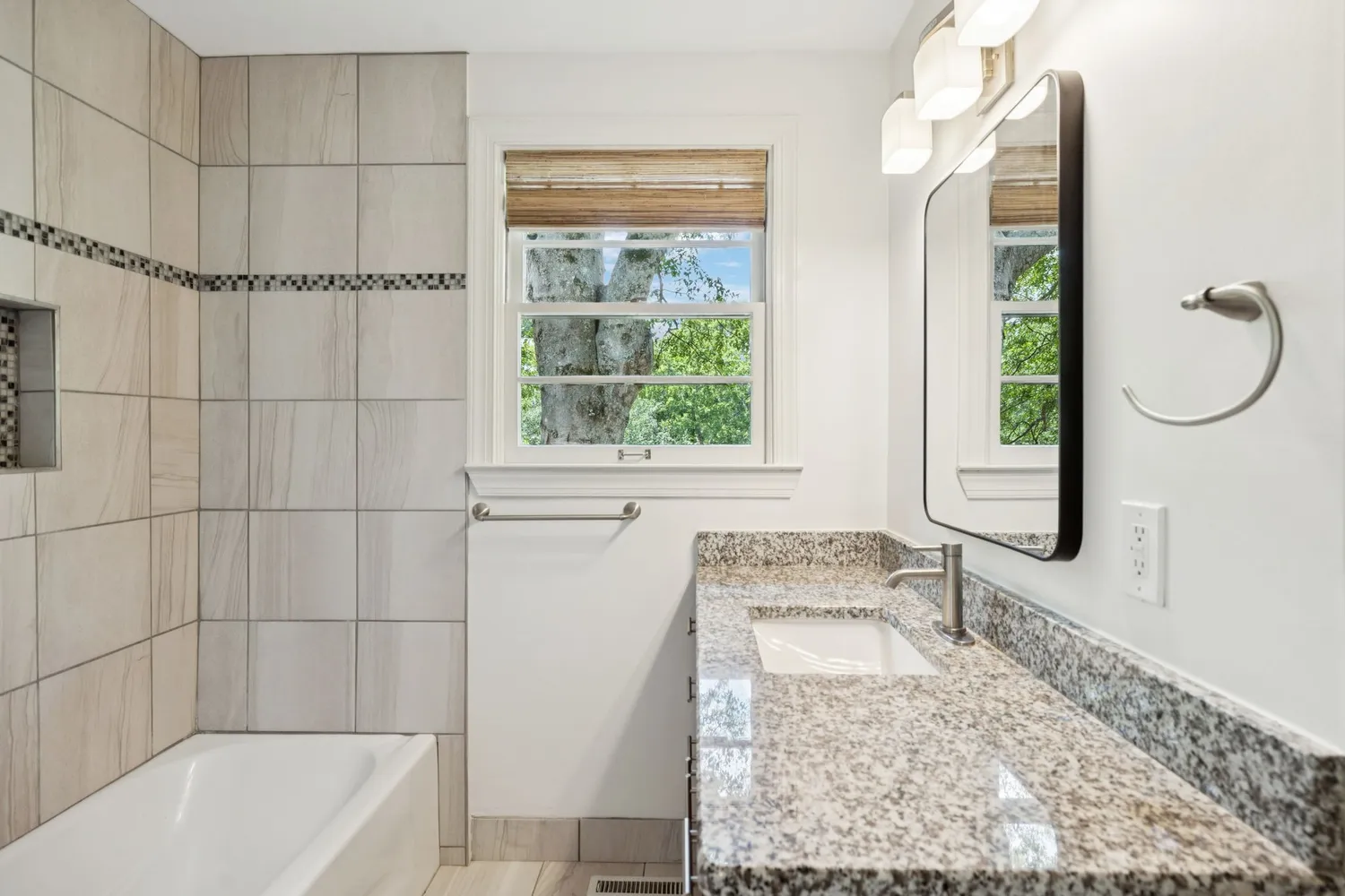 a bathroom with a granite countertop bathtub and shower