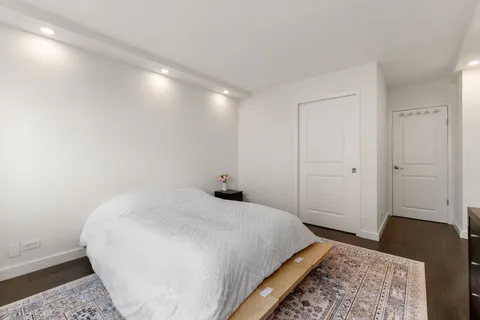 a bedroom with a bed and wooden floor