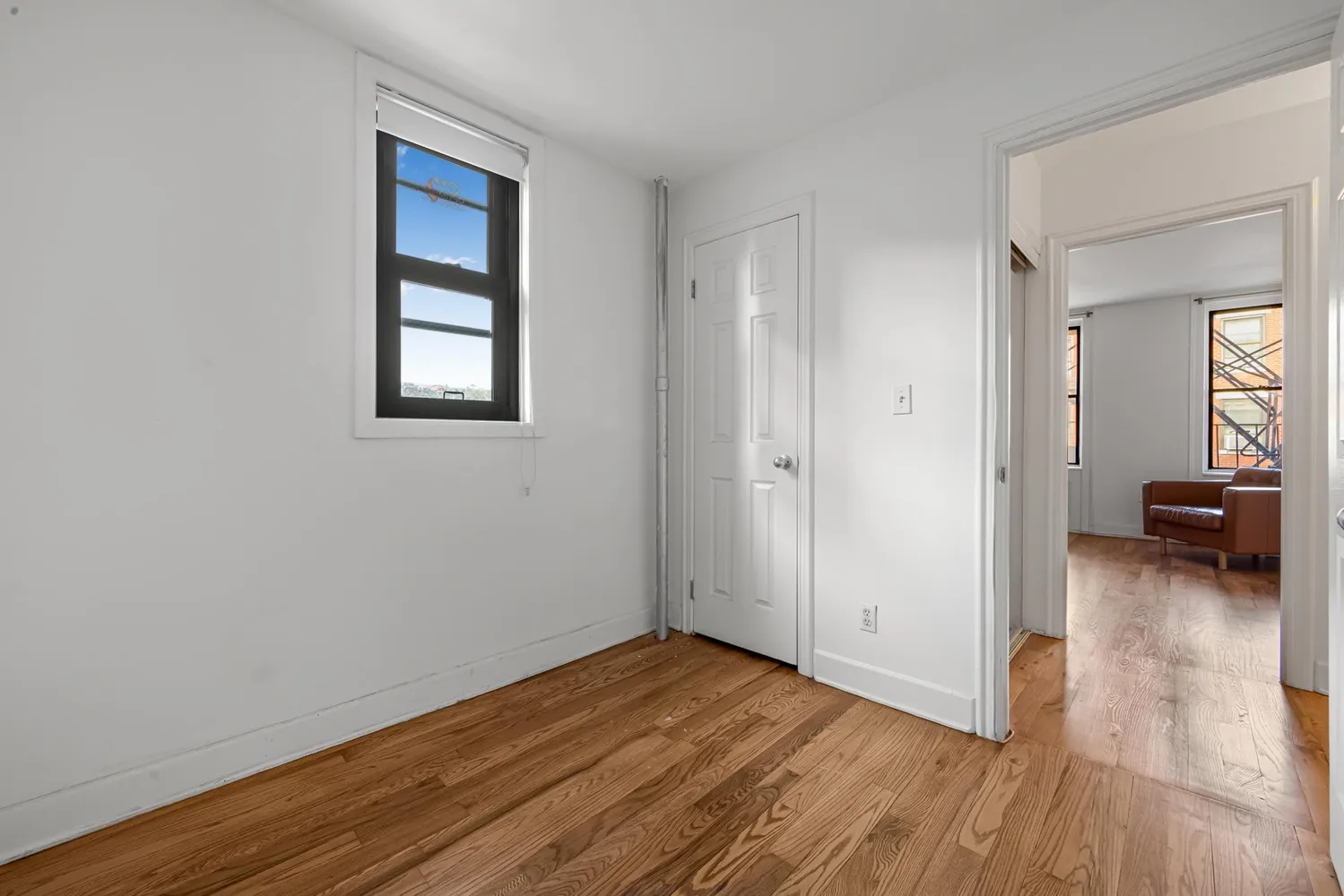 a view of a room with wooden floor and furniture