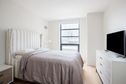 a bedroom with a bed and a flat screen tv