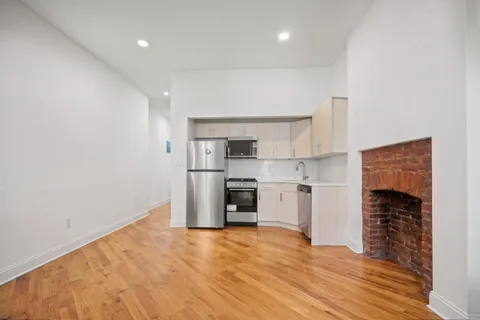 a kitchen with granite countertop a refrigerator and a stove top oven