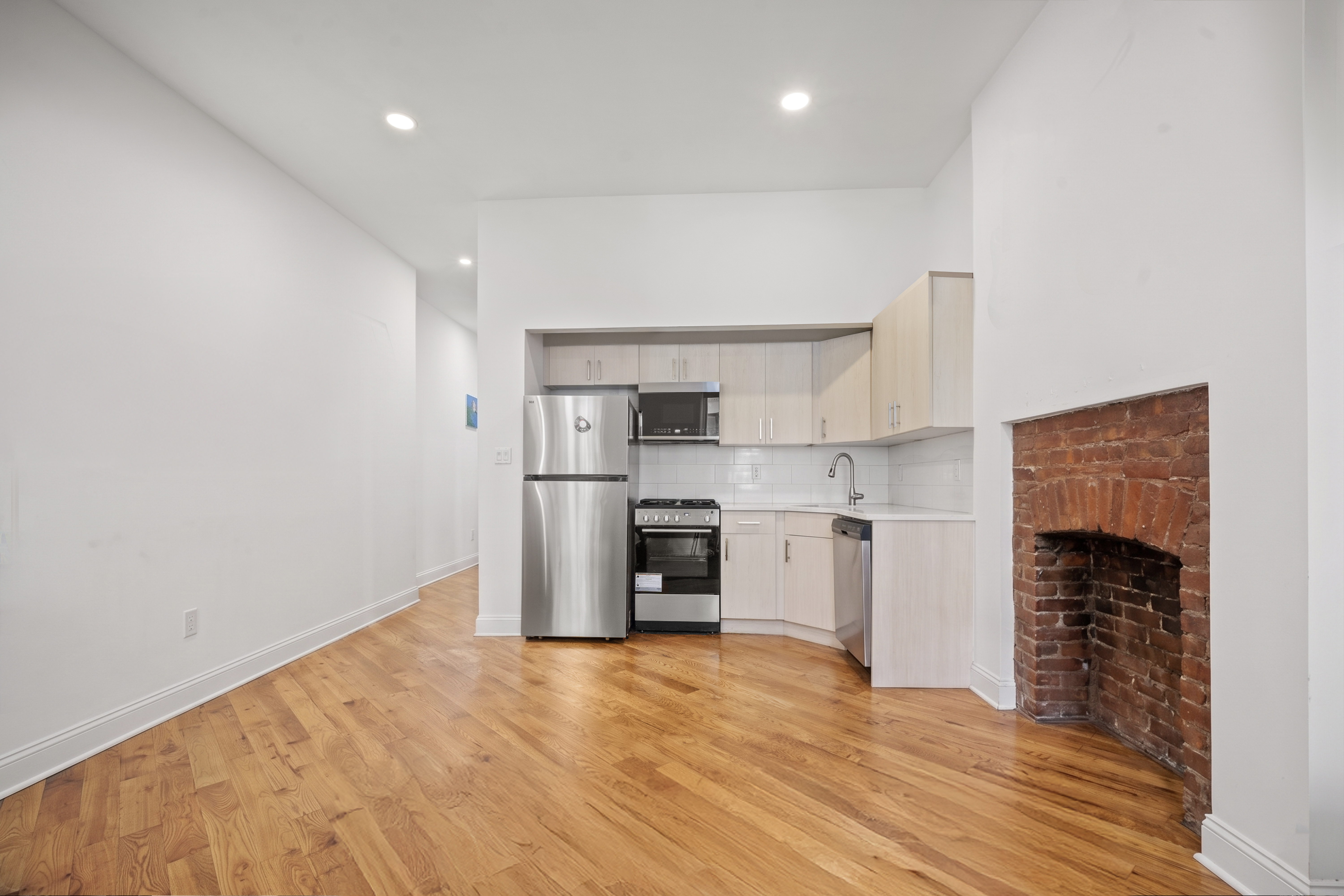 36 West 35th Street, Unit 2A Manhattan, NY 10001 - Photo 6 of 11 a kitchen with granite countertop a refrigerator and a stove top oven