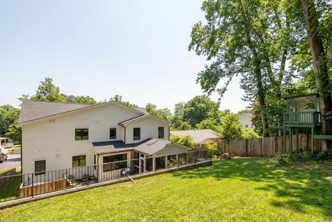 a view of a house with a backyard and chairs