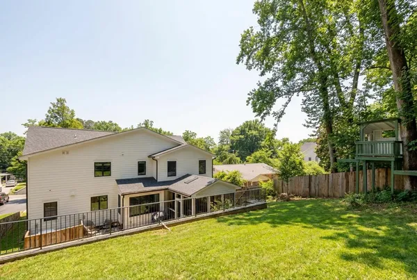a view of a house with a backyard and chairs