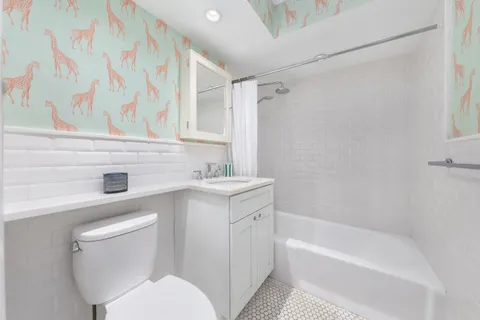 a bathroom with a sink toilet vanity and bathtub