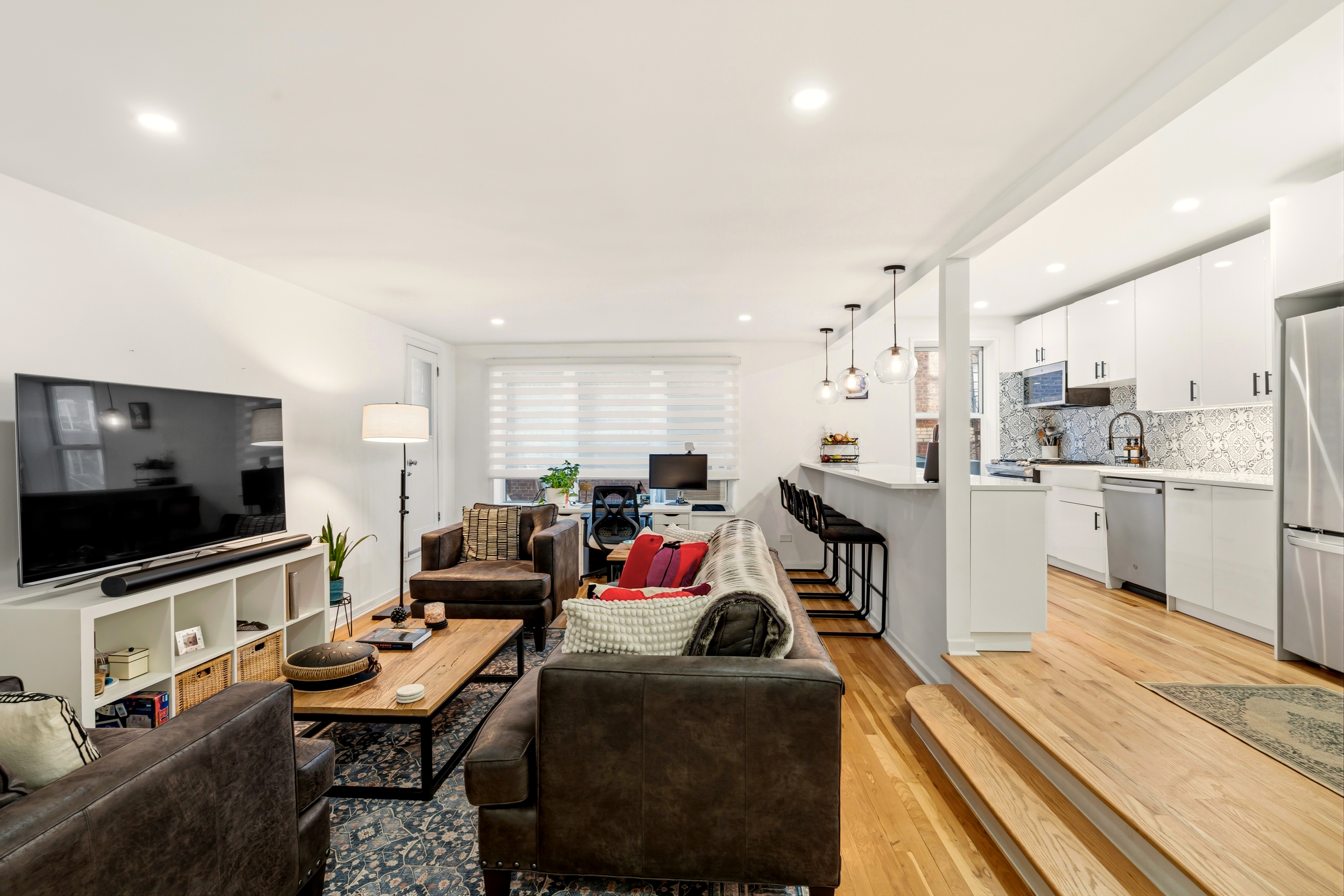 79-10 34th Avenue, Unit 2J Queens, NY 11372 - Photo 2 of 9 a living room with furniture and a flat screen tv