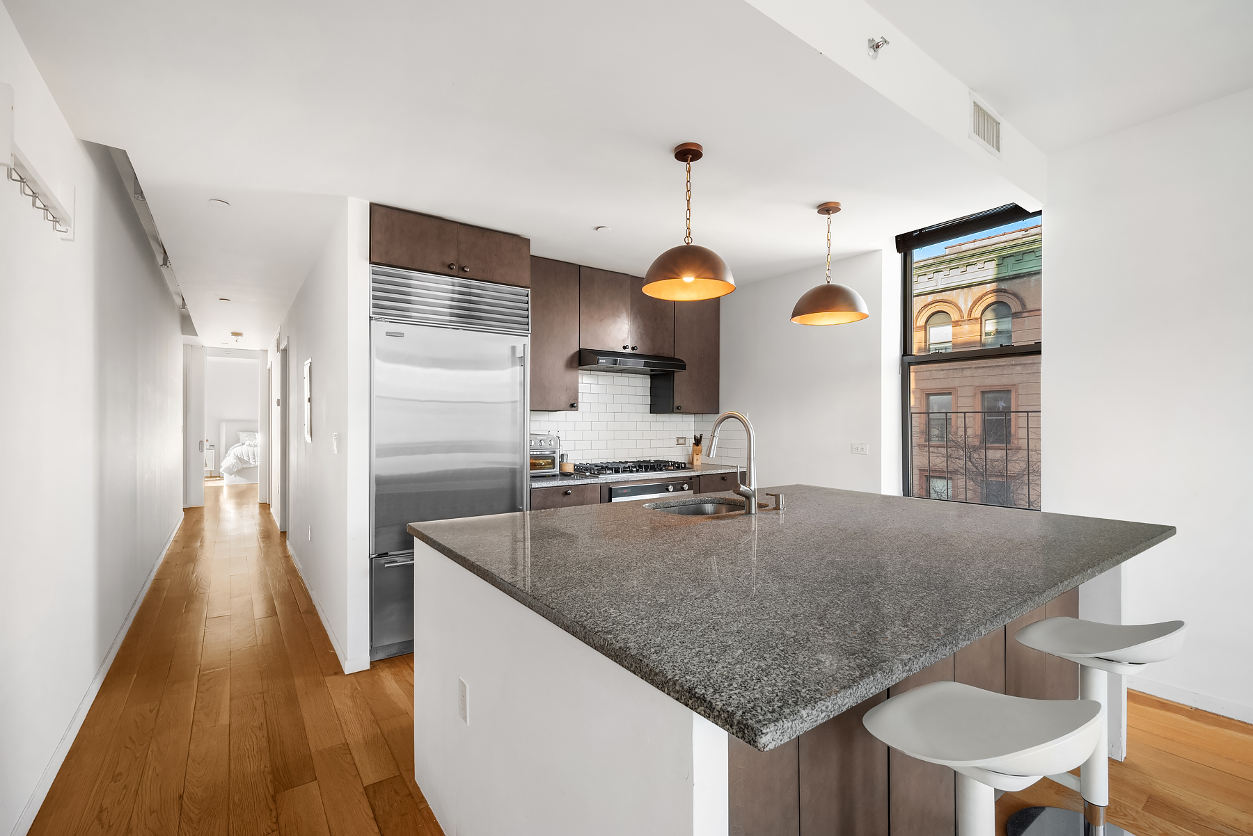2605 Frederick Douglass Boulevard, Unit 4B Manhattan, NY 10030 - Photo 2 of 8 a kitchen with stainless steel appliances granite countertop a sink refrigerator and cabinets