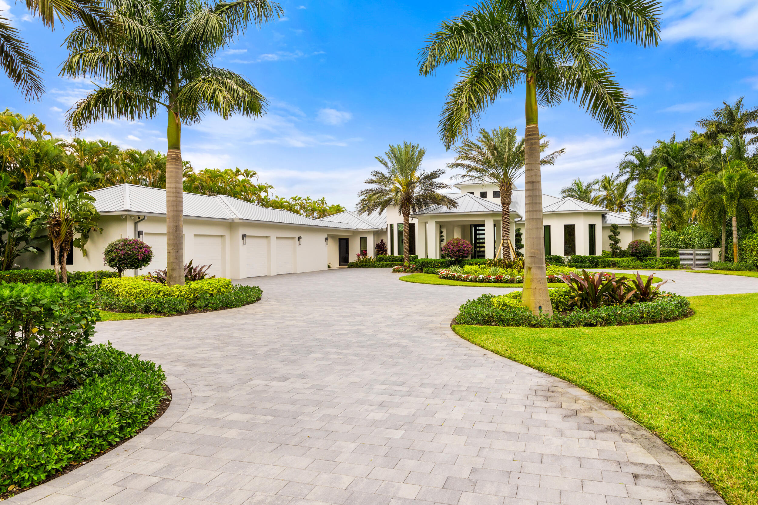 5695 Pennock Point Road Jupiter, FL 33458 - Photo 65 of 77 a view of a white house with a big yard and potted plants