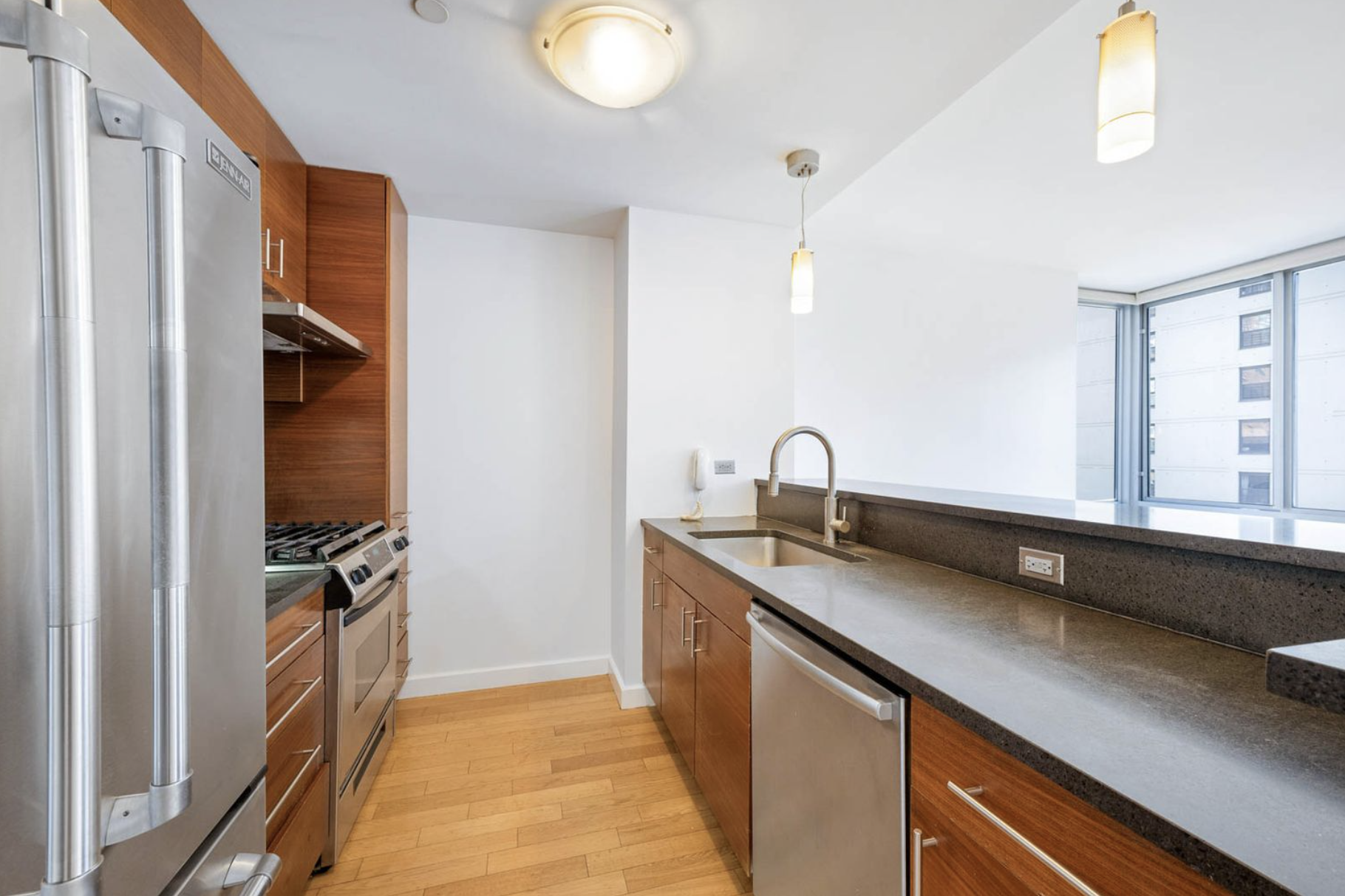 225 West 60th Street, Unit 8F Manhattan, NY 10023 - Photo 2 of 11 a kitchen with a sink and a refrigerator