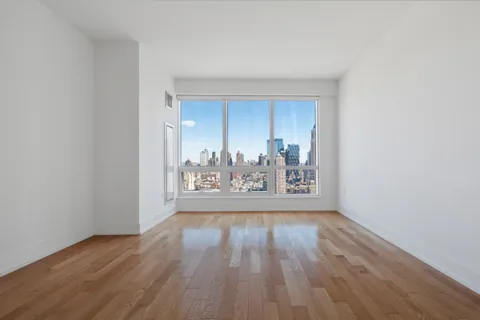 a view of a room with wooden floor and cabinets