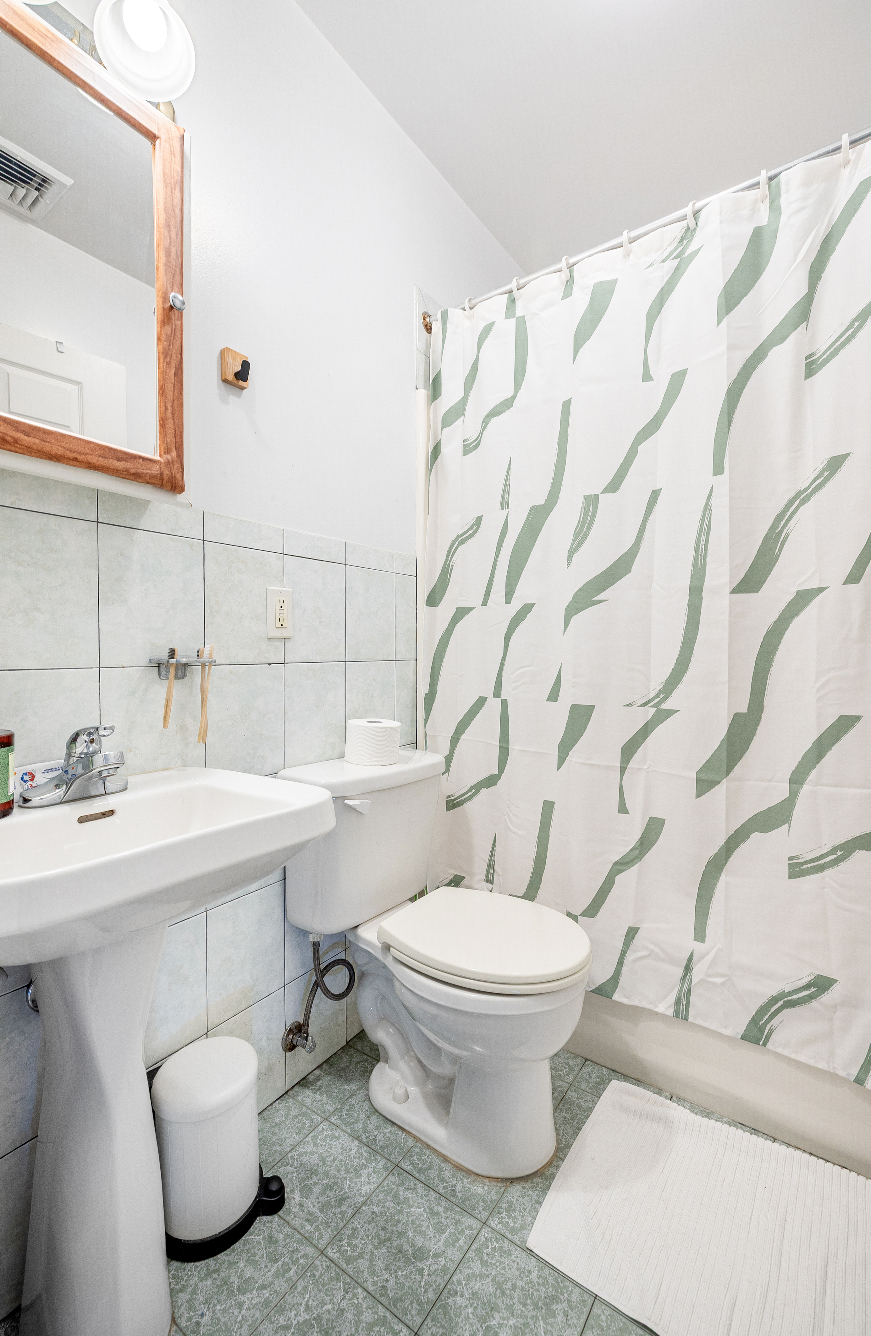 518 West 149th Street Manhattan, NY 10031 - Photo 21 of 23 a bathroom with a toilet sink and mirror