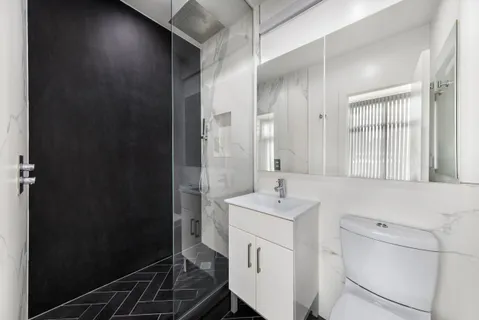 a bathroom with a sink a toilet and shower