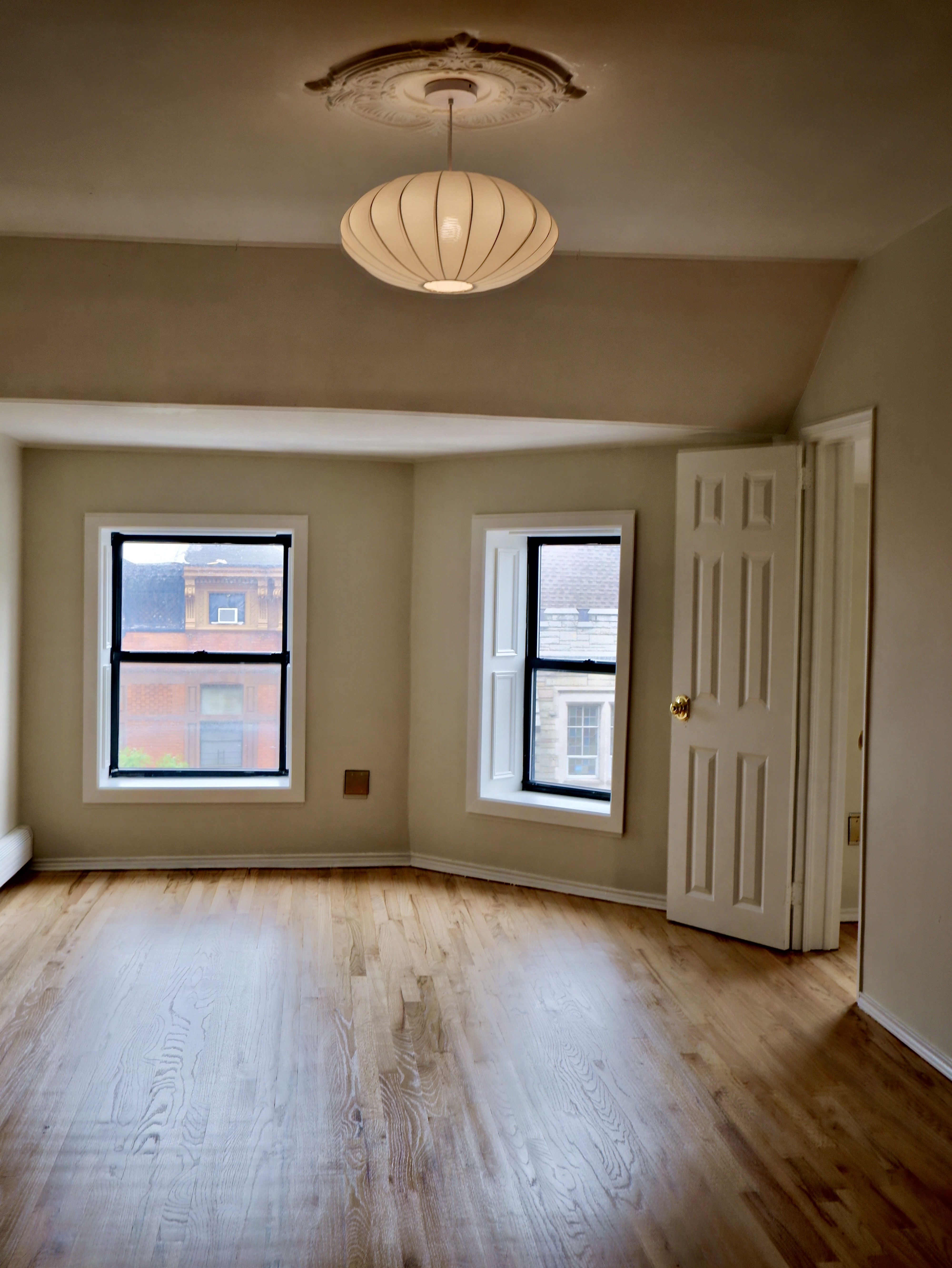 132 Decatur Street, Unit 3 Brooklyn, NY 11216 - Photo 5 of 17 a view of an empty room with wooden floor and a window