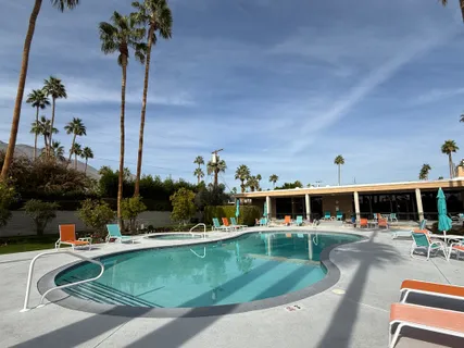 an aerial view of a swimming pool with outdoor seating