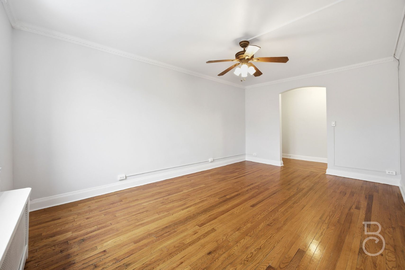 78-15 19th Drive, Unit B2 Queens, NY 11370 - Photo 11 of 17 an empty room with wooden floor ceiling fan and window
