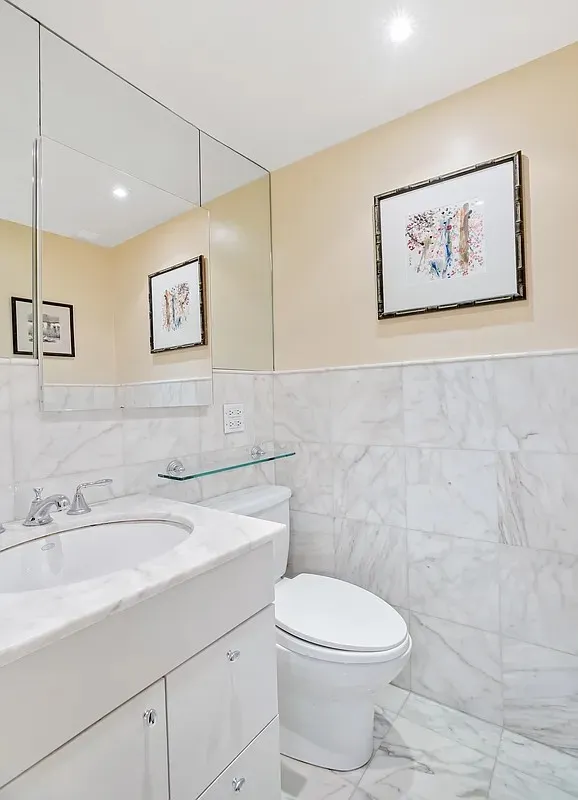 a bathroom with a toilet sink and a mirror