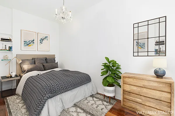 13 Downing Street, Unit 8 Manhattan, NY 10014 - Photo 7 of 10 a bedroom with a bed potted plant and a window