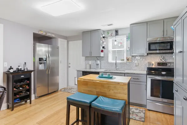 a kitchen with stainless steel appliances granite countertop a stove a sink and a refrigerator