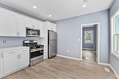 a kitchen with stainless steel appliances granite countertop a refrigerator and a stove top oven