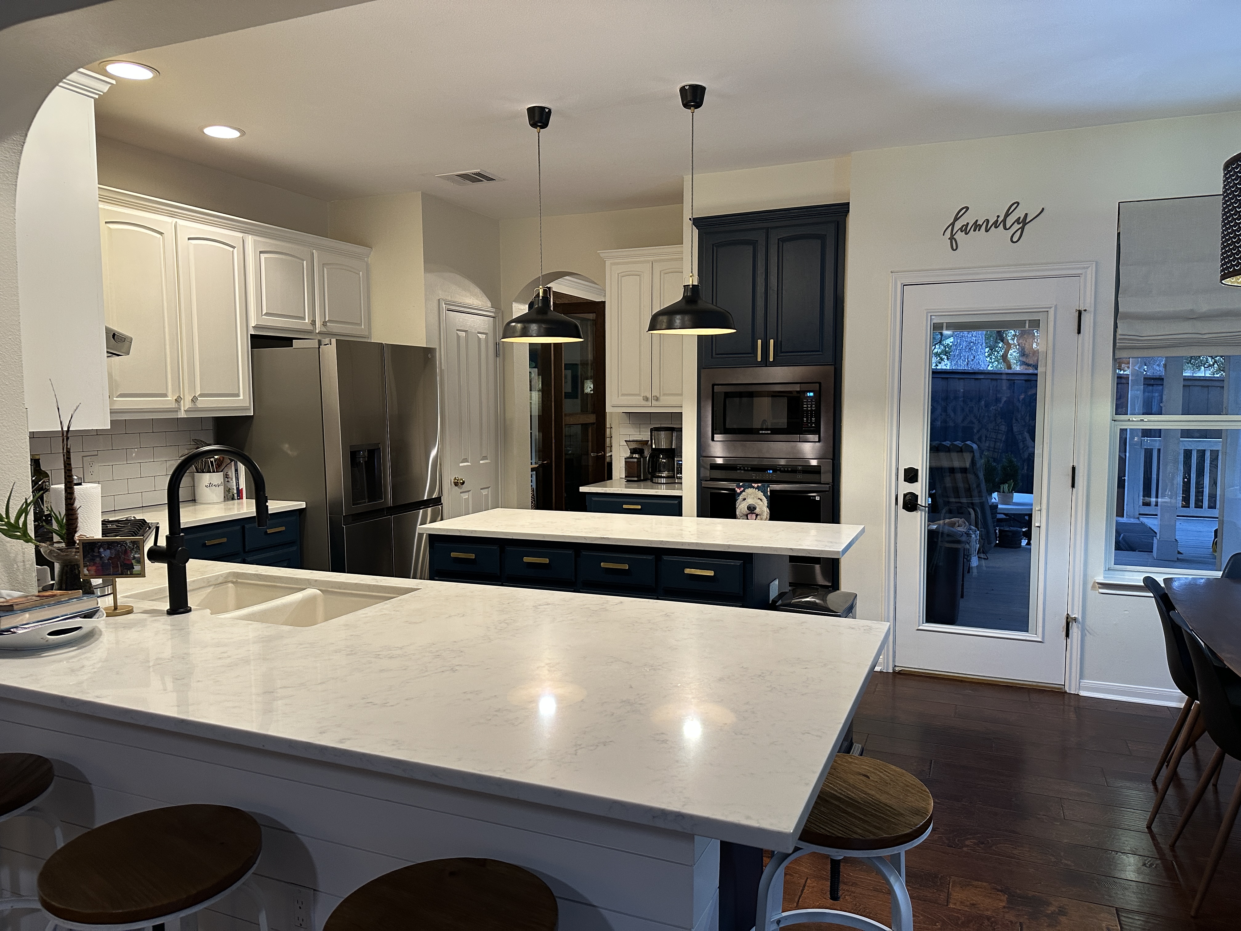 11105 Bexley Lane Austin, TX 78739 - Photo 5 of 12 a kitchen with stainless steel appliances kitchen island granite countertop a refrigerator a stove and a sink with wooden floor