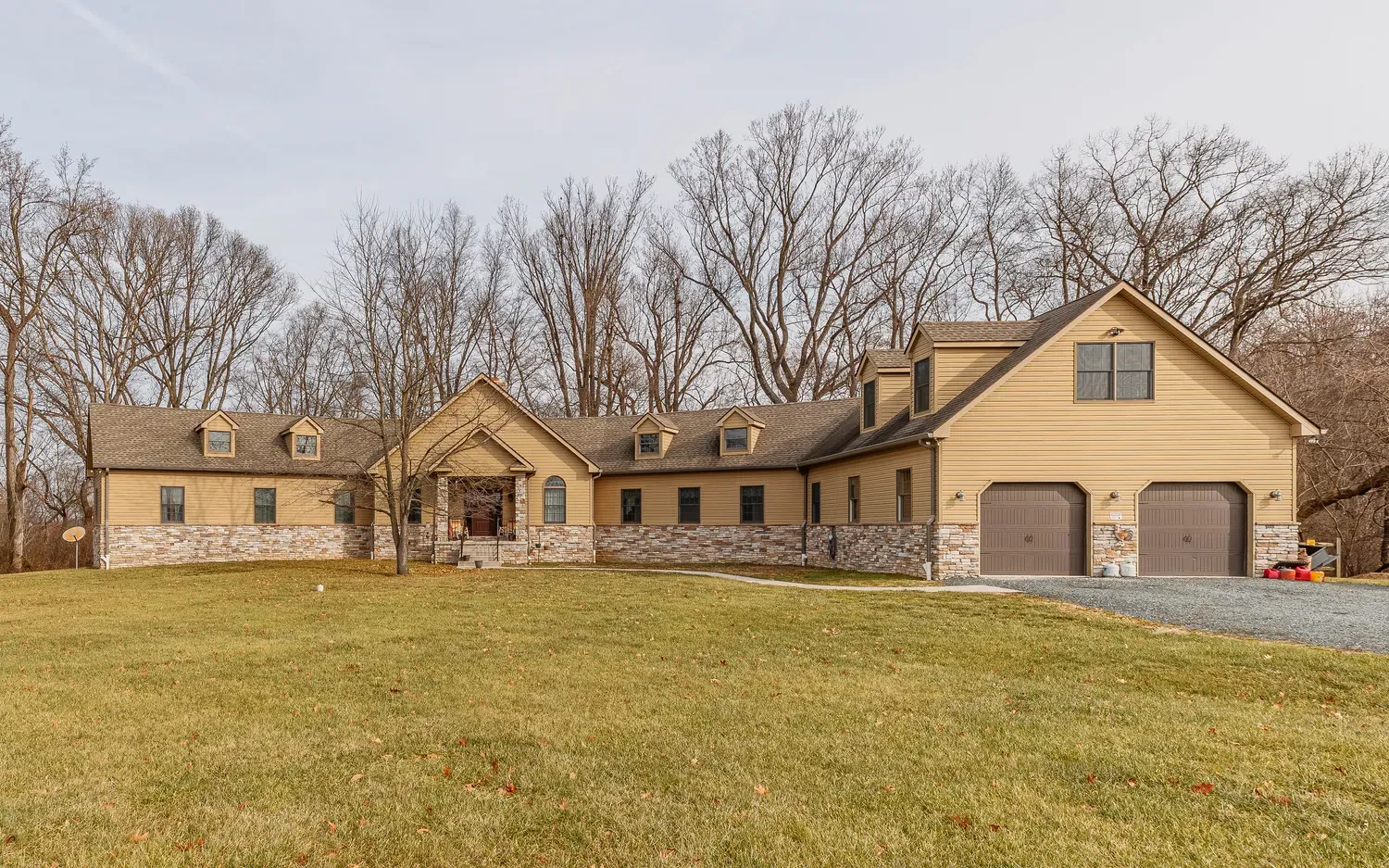 a view of a white house with a big yard and large trees
