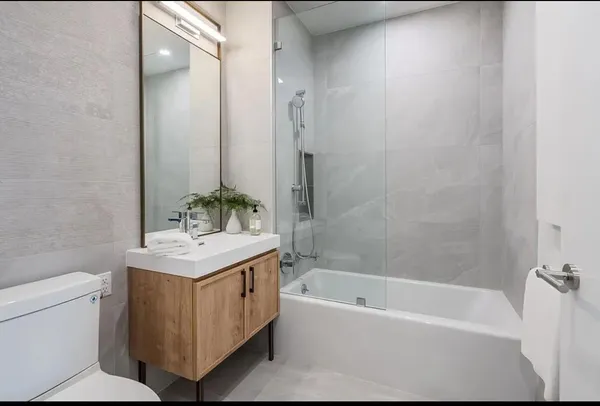 a bathroom with a sink a toilet and shower