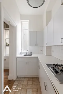 a kitchen with a sink a stove and cabinets