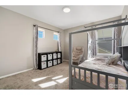 a bedroom with furniture and a large window