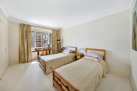 a bedroom with two beds and a window