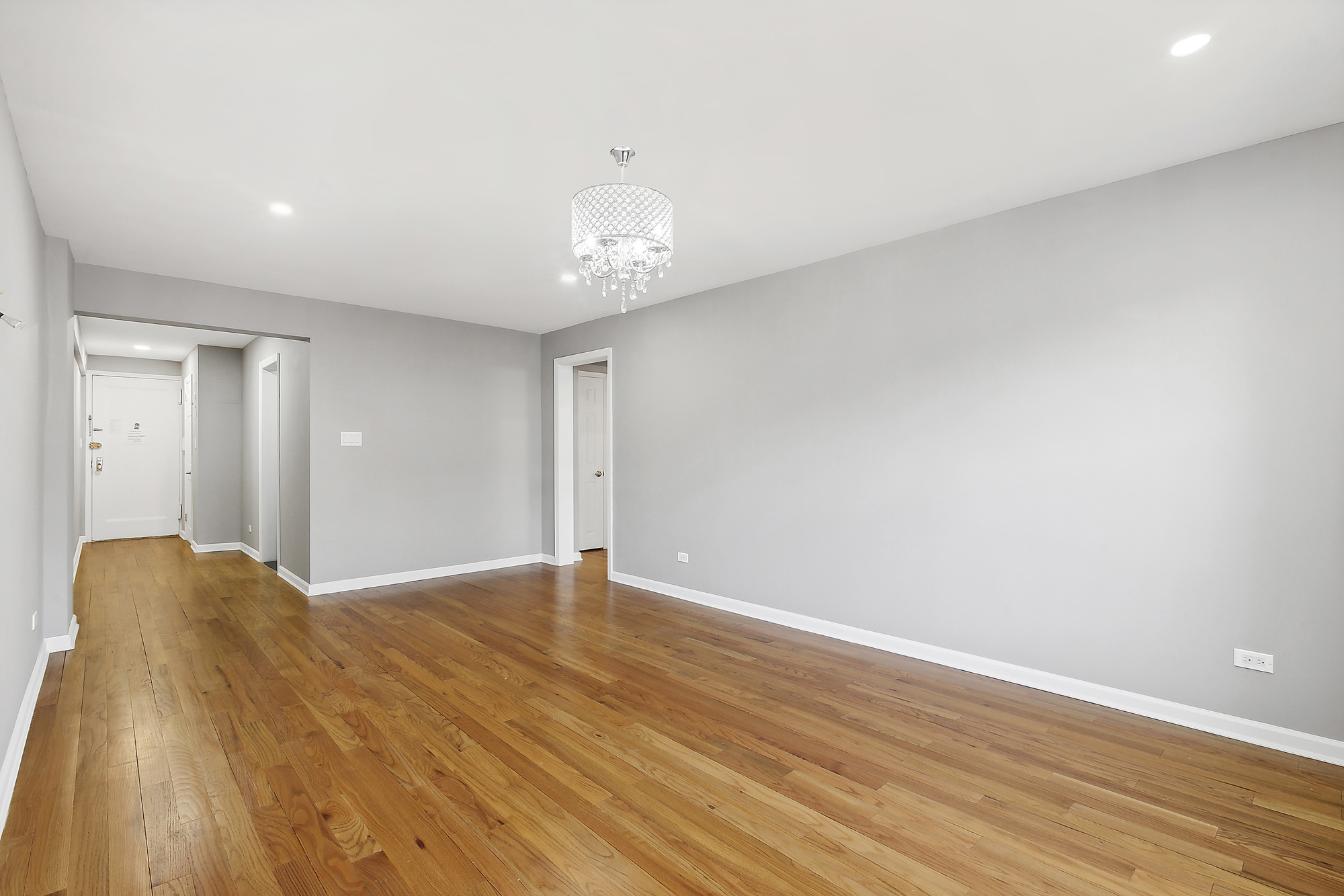 40 89th Street, Unit 1F Brooklyn, NY 11209 - Photo 3 of 13 a view of an empty room with wooden floor and a chandelier