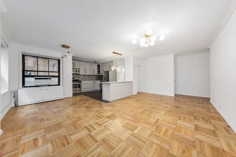 a view of a kitchen with wooden cabinet and a refrigerator