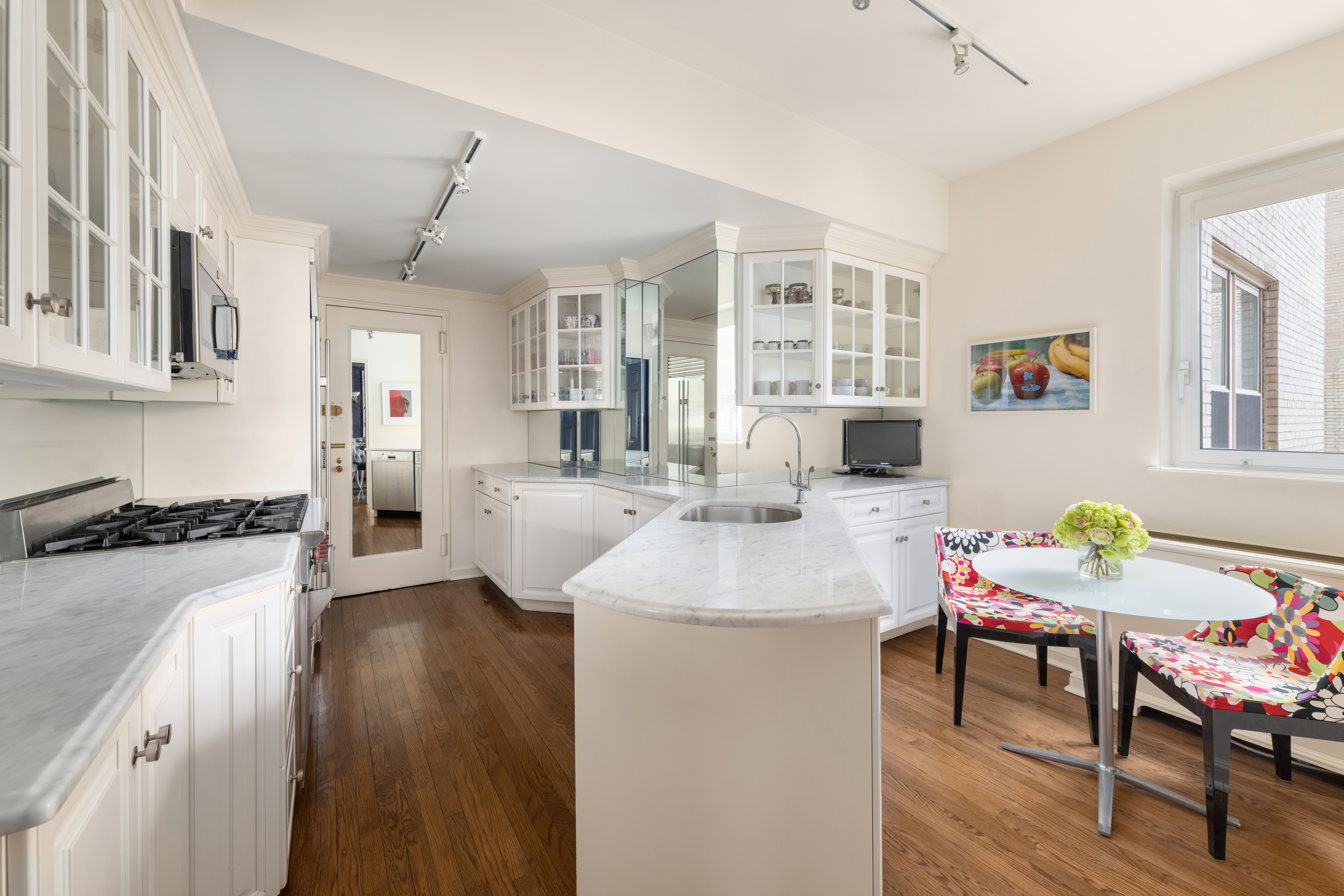 1 East 66th Street, Unit 9EF Manhattan, NY 10065 - Photo 13 of 19 a living room with furniture and a kitchen