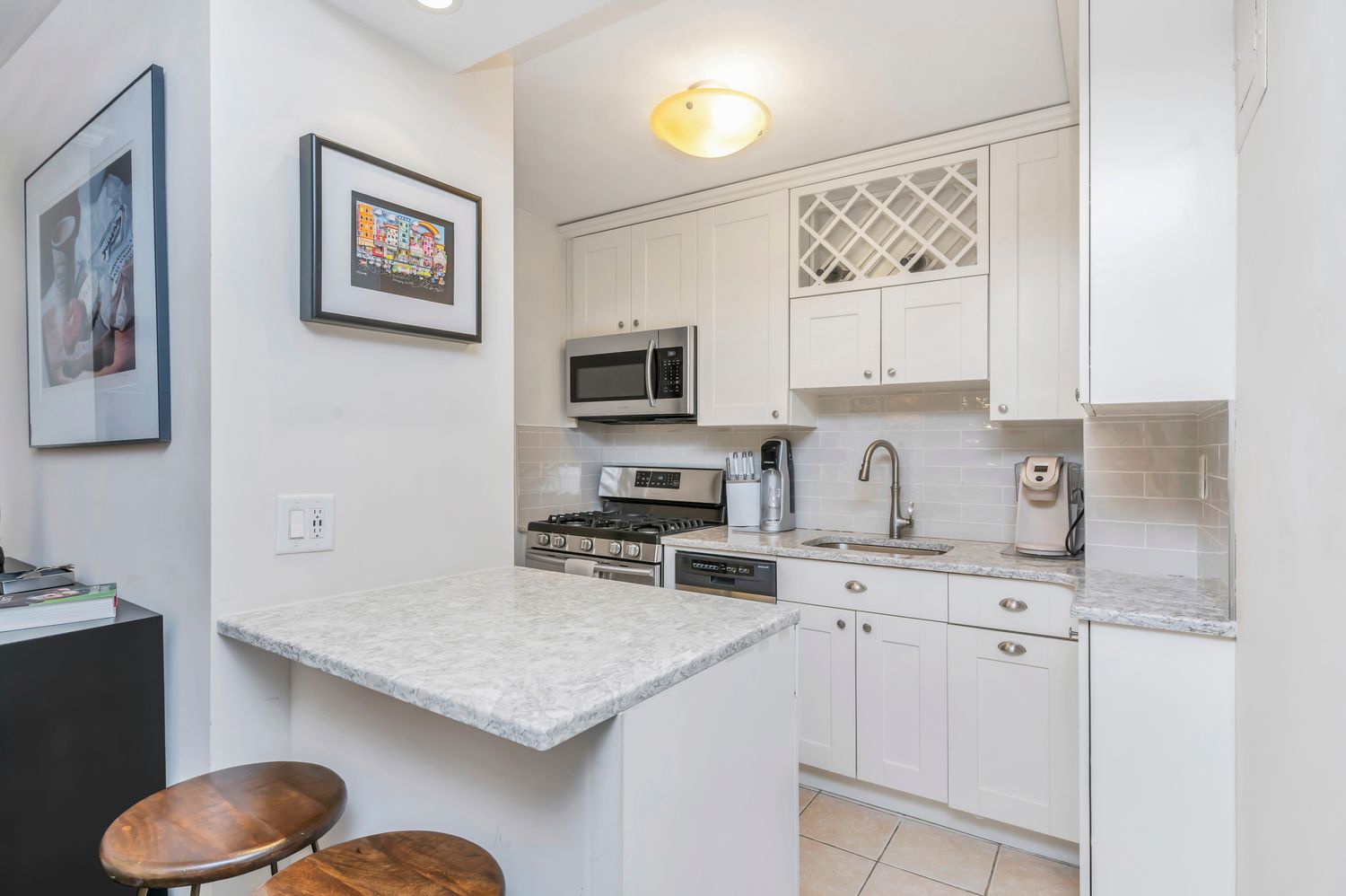 333 East 79th Street, Unit 2R Manhattan, NY 10075 - Photo 5 of 13 a kitchen with granite countertop a stove top oven sink and cabinets